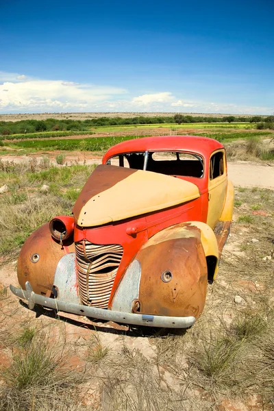 Carro abandonado no campo sob céu azul — Fotografia de Stock
