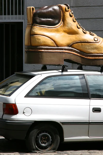 Машина с большой обувью на крыше — стоковое фото
