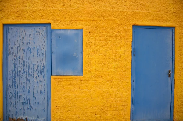 Dom żółte i niebieskie okno — Zdjęcie stockowe