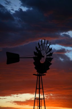 Silhouette of Farm Windmill at Sunset clipart