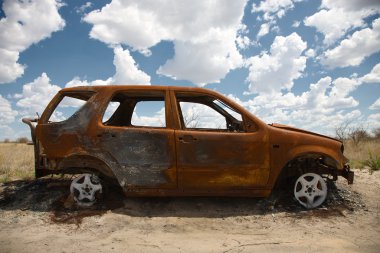 Abandoned Car in Field Under Blue Sky clipart