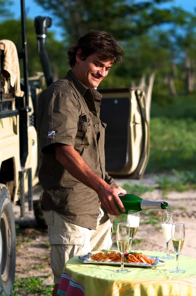 stock image Man smiling and serving champagne