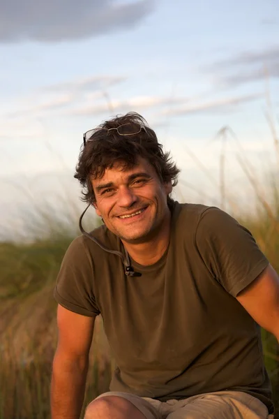 stock image Portrait of an young man sitting on a wooden bench