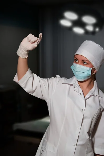 Joven bonita cirujano sosteniendo la uña para la osteosíntesis — Foto de Stock