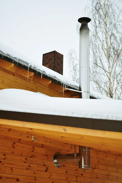 郊外の家 チューブ つらら 金属工事 コテージまたは汚された木製のシャレーの屋根の家プレハブの建物 冬の木は 聖霊降臨祭 — ストック写真