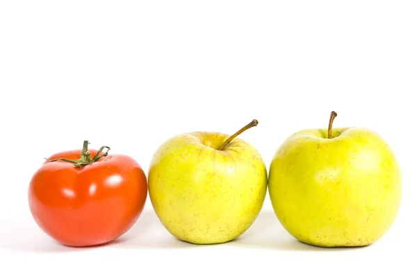 Tomate y manzanas sobre un blanco Imagen de stock