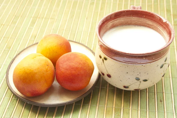 Чашка молока и абрикосы — стоковое фото