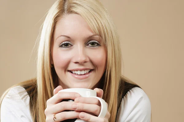 Beautiful blond drinking from a cup — Stock Photo, Image
