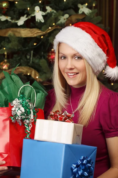 Blond female holding Christmas presents — Stock Photo, Image