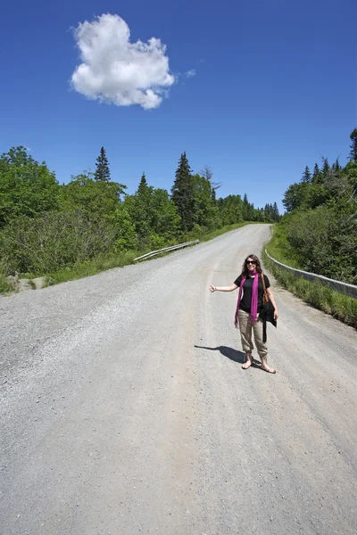 Female hitchhiker on country road — Stock Photo, Image
