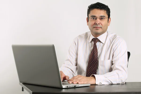 Indiase zakenman die op laptop werkt — Stockfoto