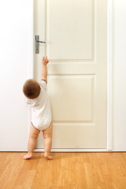 Baby boy in front of door clipart