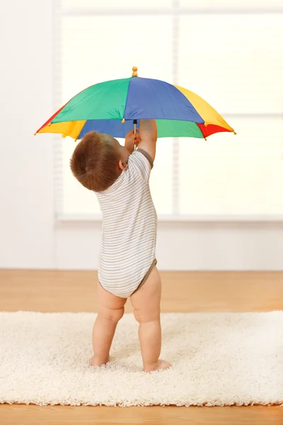 Малыш, открывающий зонтик — стоковое фото