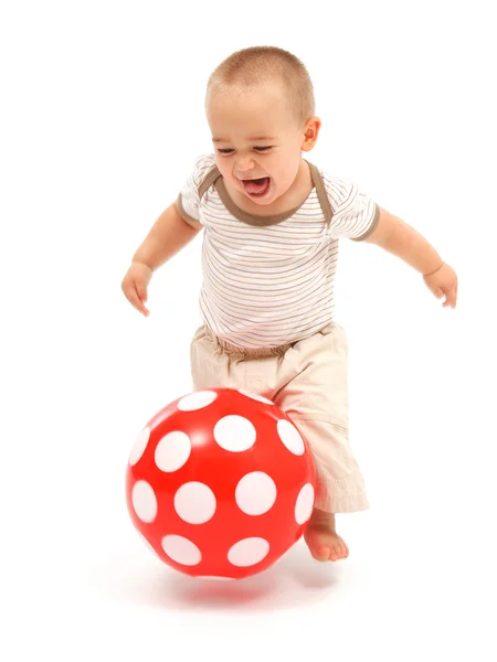 Mały chłopiec bawi się czerwoną piłkę — Zdjęcie stockowe
