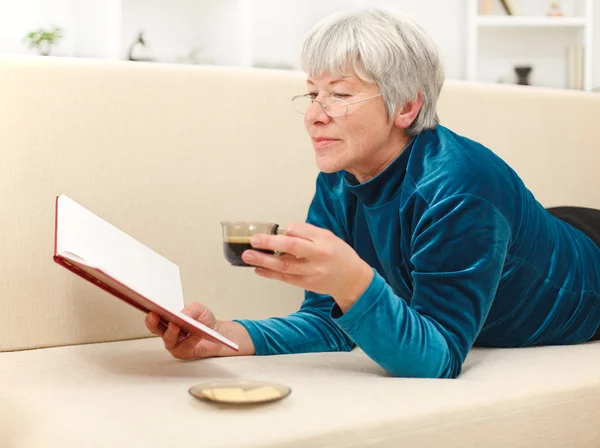 Senior woman with book and coffee