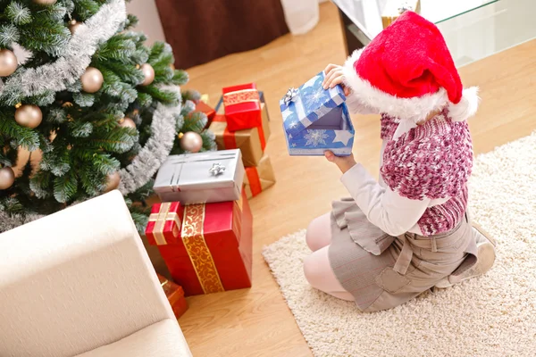 Девушка на Рождество, заглядывает в подарочную коробку — стоковое фото