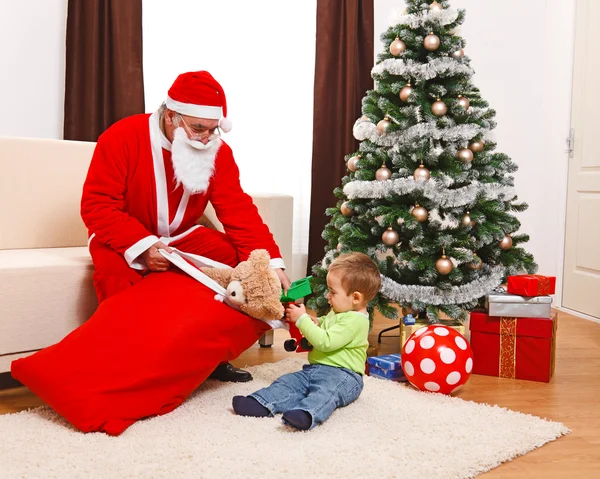 Kleiner Junge holt Spielzeug aus der Tasche des Weihnachtsmannes — Stockfoto