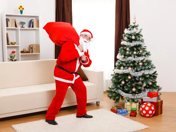 Santa claus chůzi s plnou taškou — Stock fotografie