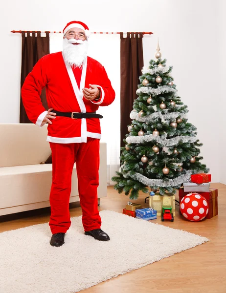 Papai Noel de pé na frente da árvore de Natal — Fotografia de Stock