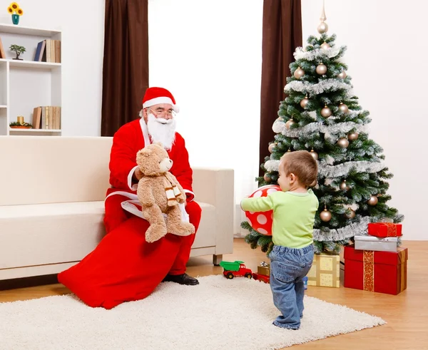 Санта Клаус показывает игрушку из сумки — стоковое фото