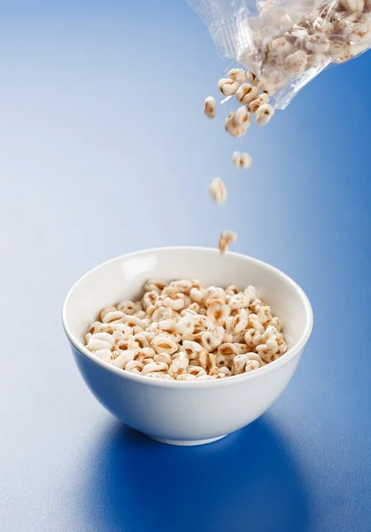 Popped wheat flakes pouring in plate — Stock Photo, Image