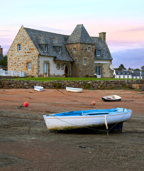 Ancient house and boats on a mooring - beautiful scenery at sunset