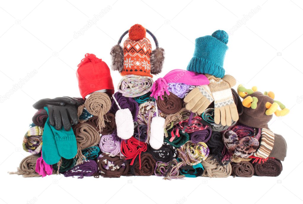 Huge pile of woolen winter scarfs, hats and gloves. Isolated over white