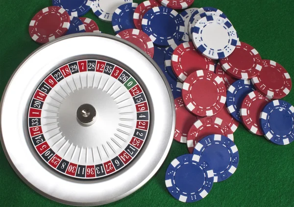 Roulette-Rad und Chips auf grünem Beize — Stockfoto