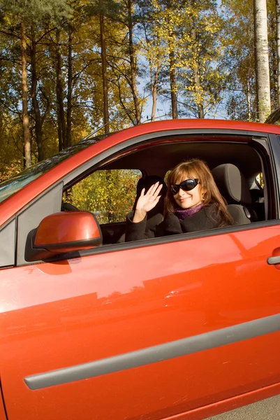 La chica en el coche rojo en un día soleado de otoño — Foto de Stock