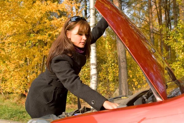 Dívka opraví auto motor — Stock fotografie
