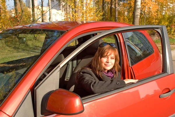 Mladé ženy v kabině její červené auto — Stock fotografie