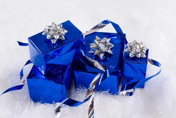 Cajas brillantes azules para regalos con cintas plateadas en la piel blanca —  Fotos de Stock