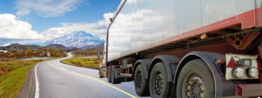 White truck on a mountain road on a sunny day clipart