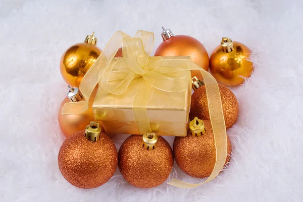 Christmas spheres and golden box on the white fur — Stock Photo, Image