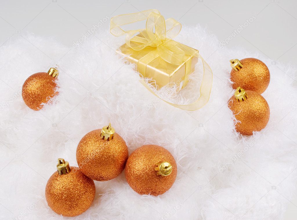 Christmas brightly golden spheres on the white fur