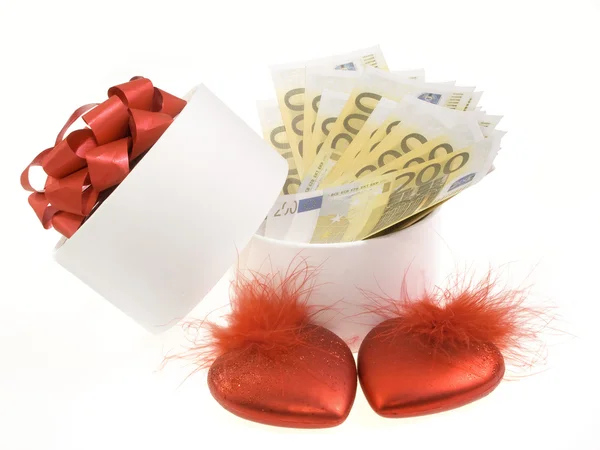 Boîte ronde blanche avec billets et cœurs rouges — Photo