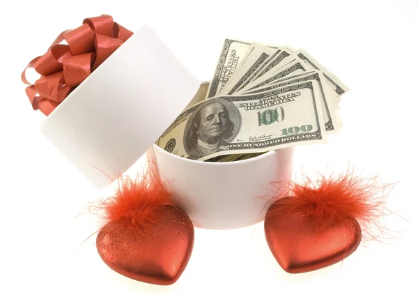 Белая круглая коробка с долларами и двумя красными сердцами — стоковое фото