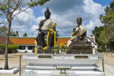 Statues of an old holy royal couple in front of the temple clipart