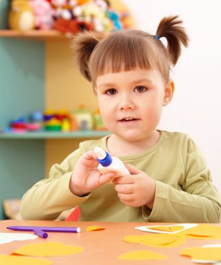 Little girl doing arts and crafts in preschool clipart