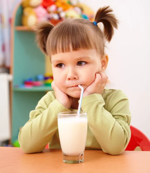 Ponury dziewczynka pije mleko — Zdjęcie stockowe