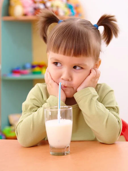 Мрачная маленькая девочка пьет молоко. — стоковое фото
