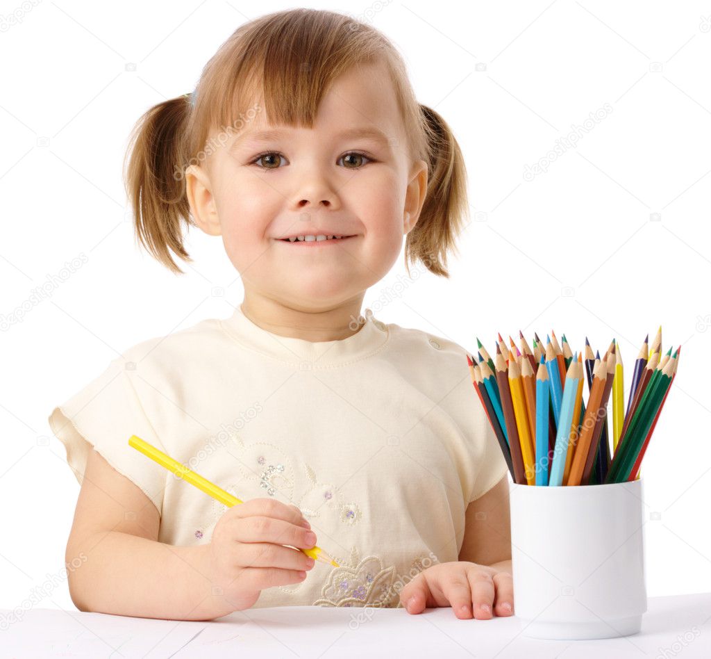 Cute child draws with color pencils