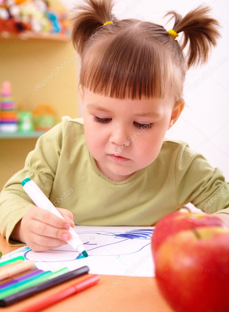 Little girl draws with felt-tip pen