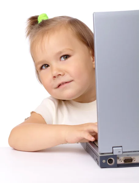 Schattig klein meisje is op zoek vanuit haar laptop — Stockfoto