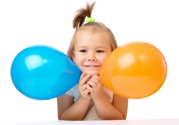 Söt liten flicka med två färgade ballonger — Stockfoto