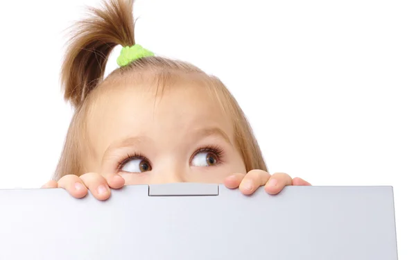 Petite fille mignonne regarde hors de son ordinateur portable — Photo