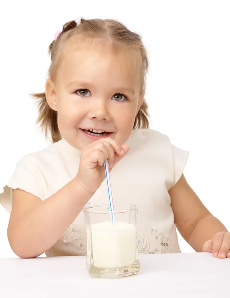 Malá holka pije mléko pomocí brčko — Stock fotografie