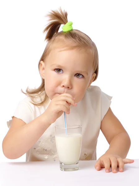 Little girl drinks milk using drinking straw — Stock Photo, Image