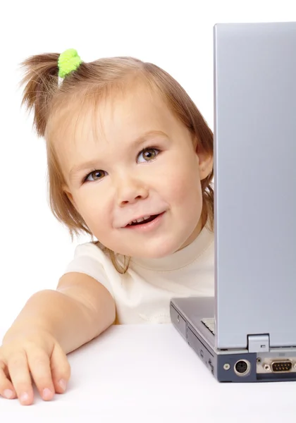 Nettes kleines Mädchen schaut aus ihrem Laptop — Stockfoto