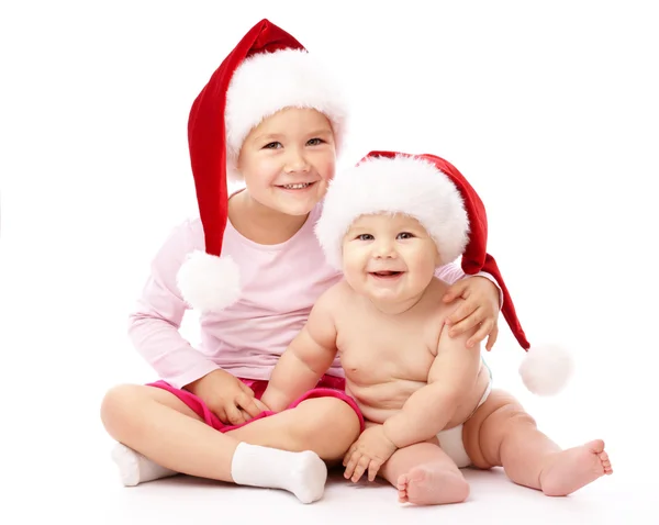 Two children wearing red Christmas caps and smile Stock Photo